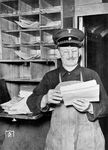 Ein Packmeister im Gepäckwagen beim Sortieren von Gepäckscheinen und Begleitpapieren der Expressgutsendungen.  (1938) <i>Foto: RVM</i>