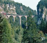 Das Landwasserviadukt ist eine 65 Meter hohe und 136 Meter lange Eisenbahnbrücke im Netz der Rhätischen Bahn in der Nähe des Bahnhofs Filisur und gilt als ein Wahrzeichen der Bahngesellschaft. Rund 22.000 Züge überqueren pro Jahr den Viadukt, täglich sind es rund 60. Der Viadukt gehört seit dem 7. Juli 2008 zum UNESCO-Weltkulturerbe.  (1981) <i>Foto: Karsten Risch</i>