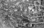 Mit voller Wucht kam der Krieg auch nach Deutschland zurück, wie dieses Luftbild eines amerikanischen Aufklärungsflugzeuges über Wuppertal-Elberfeld eindrucksvoll zeigt. Nicht ein Haus scheint in der Südstadt unbeschädigt zu sein. Nur die Gerippe der beiden Bahnhofshallen (unten) stehen noch, das davorliegende Empfangsgebäude sowie die Reichsbahndirektion (rechts unten) sind auch völlig zerstört. Bei dem Hauptangriff am 25. Juni 1943 sollen laut britischem Angriffsbericht in der Nacht 1.082 Tonnen Spreng- und 1.220 Tonnen Brandbomben über dem Zielgebiet abgeworfen worden sein. Auf diese Weise wurden etwa 3.000 Wohngebäude zerstört und 2.500 schwer beschädigt. Der Flächenbrand erreichte ein Ausmaß von 12 km². Darüber hinaus kamen 1.900 Menschen, darunter 716 Männer, 1.046 Frauen, 62 Jungen und 79 Mädchen ums Leben. Die Analyse der britischen Luftwaffe ergab eine Zerstörung von 94 Prozent der Elberfelder Bebauung. (12.04.1945) <i>Foto: US-Army</i>