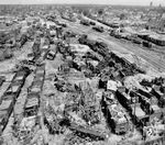 Coesfeld erlitt erst in der Endphase des Krieges vom 21. bis 24. März 1945 größere Beschädigungen. Allein am 21. März 1945 wurden rund 10.000 Spreng- und 49.000 Brandbomben bei alliierten Luftangriffen abgeworfen und verwandelten die Innenstadt in eine Ruinenlandschaft. Am Karfreitag, 30. März 1945, wurde Coesfeld von den vorrückenden britisch/amerikanischen Truppen unter Feldmarschall Bernard Montgomery ohne größere Gegenwehr eingenommen. Die amerikanische Luftaufklärung dokumentierte Anfang April die "Erfolge" ihre Luftschläge beim Überflug über den Bahnhof, in dem kein unbeschädigtes Fahrzeug auszumachen ist. Um trotz solcher immensen Schäden den Betrieb möglichst schnell wieder aufnehmen zu können, ließ die Reichsbahn nur die durchgehenden Hauptgleise reparieren, überwiegend durch den Einsatz von Kriegsgefangenen und KZ-Häftlingen, wie gut auf dem Bild zu sehen ist.  (04.1945) <i>Foto: US-Army</i>