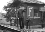 Für den Fotografen lässt der Schrankenwärter auf der Inntalbahn bei Hall in Tirol das Signalhorn ertönen. Hornsignale (Sh 5) wurden gegeben, um einen Zug zum Halten zu veranlassen, wenn das Signal Sh 1 (Kreissignal) nicht gegeben werden konnte oder nicht ausreichend erschien oder um andere Bedienstete zu veranlassen, einen Zug anzuhalten.  (1942) <i>Foto: RVM (Ittenbach)</i>