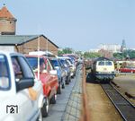 Ein abfahrbereiter Autozug in der Sylter Verladeanlage. Rechts wartet 218 170 vom Bw Flensburg. Sylt platzt mittlerweile aus allen Nähten, die Zahl der Besucher hat sich in den vergangenen 20 Jahren fast verdoppelt: von knapp 522.000 im Jahr 1990 auf 952.000 im Jahr 2017 - und die meisten kommen mit dem Auto, was mittlerweile zu teils chaotischen Verkehrsverhältnissen in Westerland führt - aber, die Bahn verdient halt auch gut daran. (1984) <i>Foto: Karsten Risch</i>