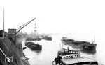 Der Wesselinger Hafen (ab 1960: Godorfer Hafen) ist der umschlagstärkste Kölner Rheinhafen. Die 1901 eröffnete Güterverkehrsstrecke Brühl – Vochem – Berzdorf – Wesseling – Godorf führte zum Bau des Hafens, dessen erstes Hafenbecken 1928 eröffnet wurde. Während anfangs hauptsächlich Braunkohle, Kies und Salz dort umgeschlagen wurde, sind es heute Öl- und Gasprodukte. (1929) <i>Foto: DLA Darmstadt (Bellingrodt)</i>