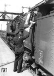 Übergabe der Zugpapiere (Wagenliste und Bremszettel) vom Zugführer an den Lokführer der 41 029 im Bahnhof Hamburg-Altona.  (03.06.1952) <i>Foto: Walter Hollnagel</i>