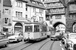 Bereits in den 1960er Jahren war der Platz zwischen Individualverkehr und Straßenbahn auch in Freiburg hart umkämpft. Tw 69 (Waggonfabrik Rastatt, Baujahr 1952) fährt mit Bw 121 durch die Oberlindenstraße. Während viele andere Städte der Straßenbahn den Garaus machten, wurde in Freiburg das Auto aus der Oberlindenstraße verbannt. (04.07.1965) <i>Foto: Helmut Röth</i>
