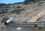 023 076 mit einem Personenzug am Hangbauwerk bei Neef an der Mosel. Der Zug wird gleich im 367 m langen Petersbergtunnel verschwinden. (14.04.1971) <i>Foto: C.J. Gammell</i>