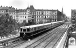 Ein S-Bahn-Sonderzug (ET 165 228) nahe Savignyplatz. Es soll sich um einen Probezug kurz vor Umstellung der Stadtbahn auf elektrischen Betrieb handeln. Im Hintergrund ist der noch unzerstörte Turm der Gedächtniskirche zu erkennen. (1928) <i>Foto: DLA Darmstadt</i>