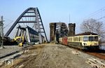 Noch stehen die alte und neue Rheinbrücke einträchtig nebeneinander, während 515 626 mit 515 616 und 815 867 als N 8126 (Düren - Düsseldorf) das rechte Rheinufer bei Düsseldorf-Hamm erreicht. (14.03.1987) <i>Foto: Wolfgang Bügel</i>
