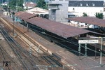 Der Bahnhof Schifferstadt ist ein Trennungsbahnhof, in dem die Strecke nach Speyer von der Pfälzischen Ludwigsbahn (Ludwigshafen - Kaiserslautern) abzweigt. Über den morbiden Bahnsteigdächern trohnt das neue Drucktastenstellwerk. (11.07.1983) <i>Foto: Oskar Bär</i>