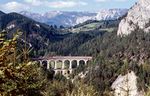 Das Kalte-Rinne-Viadukt im Adlitzgraben bei Breitenstein ist das imposanteste Viadukt auf der Semmeringbahn. Mit einer Länge von 184 m und einer Höhe von 46 m gehört es zu einem sehr beliebtesten Fotoobjekte entlang der 41 km langen Strecke. Hier überquert eine ÖBB 1042 mit einem Personenzug die Brücke. Seit 1998 gehört die Semmeringbahn zum UNESCO-Weltkulturerbe. (09.1997) <i>Foto: Hans-Jürgen Müller</i>