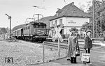 Mit einem Personenzug nach Karlsruhe fährt 144 024 aus Ersingen über den Bü an der Bahnhofsstraße. (1983) <i>Foto: Karsten Risch</i>