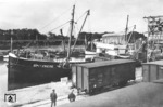 Das Küstenmotorschiff "Spitzberg" nimmt im Hafen Stolpmünde in Pommern (heute poln. Ustka) Ladung aus dem gedeckten Reichsbahnwagen "München 3991" auf. (1934) <i>Foto: RVM</i>