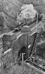 Im Streckengewirr am Giersbergtunnel hinter Siegen Hbf ist die Siegener 50 3042 mit einem Güterzug auf den Gleisen der Ruhr-Sieg-Strecke von Weidenau nach Siegen Ost unterwegs. Der Giersberg wird hier in zwei getrennten, sich im Berg kreuzenden Tunnelröhren, durchquert. Er ist in Deutschland der einzige seiner Art, der nach wie vor befahren wird und heute auf der Denkmalliste steht.  (12.09.1964) <i>Foto: Gerhard Moll</i>