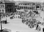 Menschenmassen am 1. Mai 1934 am alten Heidelberger Hauptbahnhof. In der Zeit des Nationalsozialismus wurde der 1. Mai ab 1933 zum gesetzlichen Feiertag und nahm auch in den folgenden Jahren eine wichtige Rolle ein. Die Maibäume wurden mit Symbolen des Regimes versehen. Gebäude wurden geschmückt und am Feiertag selbst marschierten Umzüge mit Gruppen der SA, SS, Wehrmacht und Hitlerjugend durch die Straßen. Ob die hier gezeigten Personen auf dem Weg zu einer Kundgebung sind oder tatsächlich nur den neuen Feiertag genießen, geht aus dem Kontext des Bildes nicht hervor. (01.05.1934) <i>Foto: RVM</i>