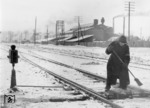 Eine einheimische Hilfskraft säubert im Schneetreiben eine Weiche im Bahnhof Orscha. (1942) <i>Foto: RVM (Donath)</i>
