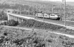 103 003 mit einem Messzug auf der NBS-Schnellfahrstrecke Hannover - Würzburg auf der 704 m langen Sinntalbrücke Zeitlofs bei Mottgers. Die 327 Kilometer lange Neubaustrecke wurde seit den 1970er Jahren geplant, ab 1973 gebaut und zwischen 1988 und 1991 abschnittsweise in Betrieb genommen. Zum Bau der Trasse, die durch 63 Tunnel und über 34 Brücken führt, wurden rund 40 Millionen DM pro km (20,5 Millionen Euro) aufgewendet. Die Trasse gilt heute als Rückgrat des Nord-Süd-Bahnverkehrs in Deutschland. Auf dem für die Rekordfahrt speziell hergerichteten südlichen Abschnitt Würzburg–Fulda stellte der Versuchszug ICE-V im Rahmen der ICE-Weltrekordfahrt am 1. Mai 1988 mit einer Geschwindigkeit von 406,9 km/h einen Weltrekord für Schienenfahrzeuge auf. (1988) <i>Foto: Karsten Risch</i>