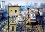 DR 118 309 (Bw Berlin-Grunewald) fährt mit einem Güterzug aus dem Güterbahnhof Berlin-Halensee. Das einem Plattenbau ähnelnde Stellwerk "Hsb" ersetzte nach dem Krieg ein abgängiges mechanisches Stellwerk der Bauart S&H 1901 aus dem Jahr 1903 und ging im Sptember 1982 außer Betrieb. Im Hintergrund ist der Funkturm zu sehen. (1980) <i>Foto: Karsten Risch</i>