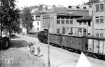 Durch die Rahmedestraße in Altena rollt Lok 21 mit ihrem Güterzug. Der Fotograf stand im Hügelweg vor der Fa. Diedrich Hesse KG, einem alteingesessenen Unternehmen der Altenaer Drahtindustrie, in der Rahmedestraße 111/123. (24.07.1958) <i>Foto: Jacques H. Renaud</i>