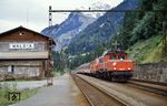 ÖBB 1020.15 (ex E 94 130) leistet einer 1044 Vorspann vor einem Schnellzug auf der Arlbergstrecke in Wald. Gut zu erkennen ist das Gefälle in Richtung Dalaas. (22.09.1984) <i>Foto: A. Wagner</i>