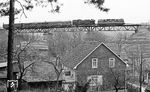 Eine DR 118 mit einer 65.10 auf dem Viadukt in Angelroda. Bei dem Viadukt handelt es sich um eine auf zwei Pfeilern ruhende Stahlfachwerkbrücke, deren Dämme mit Quadersteinen terrassenförmig verkleidet sind. Die Stahlpfeiler der Brücke wurden 1904 einbetoniert, um eine größere Belastbarkeit zu erreichen. (04.1977) <i>Foto: Burkhard Wollny</i>