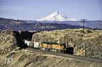 Ein Güterzug der BNSF mit zwei Dash 9 dieselelektrischen Lokomotiven des US-amerikanischen Lokomotivherstellers General Electric bei Dants, östlich von Portland in Oregon. Im Hintergrund ist der markante Mount Hood zu sehen, mit 3425 m der höchste Berg in Oregon. (12.02.2014) <i>Foto: Martin Robinson</i>