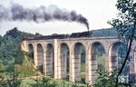 Etwa drei Kilometer vor Altenbeken liegt das Dunetal-Viadukt, über das gerade 043 189 (44 189) mit einem Durchgangsgüterzug von Hamm nach Kassel kachelt. Dank Borkenkäufer ist dieser seit Jahren zugewachsene Blick im Jahr 2022 wieder möglich. (19.07.1969) <i>Foto: Robin Fell</i>
