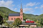 Die bekannteste Fotostelle auf der Wieslauterbahn ist wohl die protestantische Kirche in der pfälzischen Gemeinde Wilgartswiesen. Mit einem Sonderzug aus Dahn Süd rollt V 100 1019 der UEF vorbei. (05.10.2022) <i>Foto: Zeno Pillmann</i>