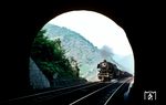 044 170 vom Bw Ehrang überquert gerade die Mosel in Ediger-Eller und wird nun in den 367 m langen Petersberg-Tunnel einfahren. Auf der anderen Seite des Tunnels liegt Neef. (04.09.1971) <i>Foto: Manfred Thielen</i>