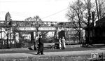 Ein Schwebebahnzug der Baureihe 1903 fährt in die Endstation Oberbarmen ein. Die Personen im Vordergrund warten auf dem Bahnsteig Gleis 1/2 auf den Zug im Bahnhof Wuppertal-Oberbarmen. (11.1952) <i>Foto: Karl Wyrsch, Slg. D. Ammann</i>
