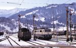 194 048 macht sich im Bahnhof Garmisch-Partenkirchen bereit, den E 3680 nach Reutte in Tirol zu übernehmen. Daneben steht die Münchener 111 059. (21.03.1985) <i>Foto: Prof. Dr. Willi Hager</i>