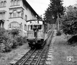 Ein zum 75-jährigen Jubiläum geschmückter Wagen der Turmbergbahn in Karlsruhe-Durlach. Die Turmbergbahn wurde am 1. Mai 1888 eröffnet. Der Antrieb erfolgte durch Schwerkraft mit Wasserballast, das heißt ein Tank im talwärts fahrenden Wagen wurde mit der erforderlichen Menge Wasser befüllt und zog den bergwärts fahrenden nach oben. Die meterspurige Strecke war dreischienig, nur im Bereich der Ausweiche zweigleisig. Außerdem besaß sie zusätzlich Riggenbach-Zahnstangen zur Bremsung der Fahrzeuge. (09.1963) <i>Foto: Reinhard Todt</i>