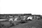 Eine unbekannte 03 überquert die behelfsmäßig gesicherte Emsbrücke bei Rheine. Die 1856 gebaute Steinbogenbrücke ist im April 1945 gesprengt worden und wurde zunächst durch die im Bild sichtbare Behelfsbrücke ersetzt. Um 1960 wurde auf den alten Pfeilern von 1856 eine Blechträgerbruecke gebaut, die noch heute vorhanden ist. (16.05.1952) <i>Foto: Quebe</i>