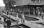 Die Angehörigen des Milupawerkes aus Friedrichsdorf (Taunus) sind in Eltville angekommen. Die höhengleichen Übergänge sind heute verschwunden und wurden durch eine Unterführung ersetzt. Der Bahnhof Eltville ist der einzige Bahnhof zwischen Rüdesheim und Wiesbaden Hauptbahnhof, der noch über ein drittes Gleis verfügt. Von 1895 bis 1922 verkehrte vom Bahnhofsvorplatz aus durch die Weinberge eine Kleinbahn zum Kurort Schlangenbad.  (06.1961) <i>Foto: Winfried Gronwald</i>