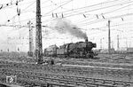 051 696 vom Bw Oberhausen-Osterfeld Süd bespannt im Rangierbahnhof Hohenbudberg einen Güterzug, dessen erster Wagen ein vierachsiger KKds 55 ist. Der Bahnhof war in seiner Blütezeit einer der größten Verschiebebahnhöfe Deutschlands. Er existierte von 1906 bis 1986. Die Länge des Bahnhofsgeländes maß 3,2 Kilometer, an der breitesten Stelle lagen bis zu 73 Gleise nebeneinander. Mitte der 1950er-Jahre verfügte der Bahnhof über 145 Kilometer Gleisanlagen und 425 Weichen. 1955 wurden 58.100 Züge mit 1.266.400 Wagen abgefertigt, täglich also etwa 160 Züge. Für den Rangierdienst standen 80 Dampflokomotiven zur Verfügung. In Spitzenzeiten wurden 200 bis 300 Züge mit 3.500 Wagen, maximal bis zu 5.000 Wagen, zusammengestellt. In der Blütezeit zählte der Bahnhof 1150 Beschäftigte, Mitte der 1970er Jahre waren es noch etwa 900. Er verfügte über eine große Wagenhalle, zwei 23-Meter-Drehscheiben, einen großen Lokomotivschuppen mit Betriebswerkstatt und Nebengebäuden mit Übernachtungsgebäude sowie zehn Stellwerke.  (12.06.1969) <i>Foto: Wolfgang Bügel</i>