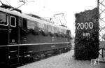 Am 4. Juni 1955 wurde der erste elektrische Teilabschnitt der Rheintalbahn Basel - Freiburg mit deutschen und schweizer Gästen feierlich dem Verkehr übergeben. In dem kleinen Ort Schliengen konnte die DB zudem ihren 2000. elektrifizierten Streckenkilometer einweihen. Die Eröffnungsfahrt wurde mit der (fast) neuen E 10 002 des Bw Nürnberg Hbf durchgeführt, die sich an dem mit viel Tannengrün geschmückten Fahrleitungsmast am km 2000 präsentiert. (04.06.1955) <i>Foto: Willi Pragher</i>