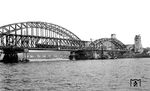 Die am 6. März 1945 von deutschen Truppen gesprengte Hohenzollernbrücke wurde als Provisorium am 8. Mai 1948 notdürftig wieder benutzbar gemacht. Ab 1951 folgte der Ausbau zur viergleisigen Brücke, der hier noch in vollem Gange ist. Eine entstromte 01.10 fährt derweil über den Rhein auf den Kölner Hauptbahnhof zu. (11.1952) <i>Foto: Karl Wyrsch, Slg. D. Ammann</i>
